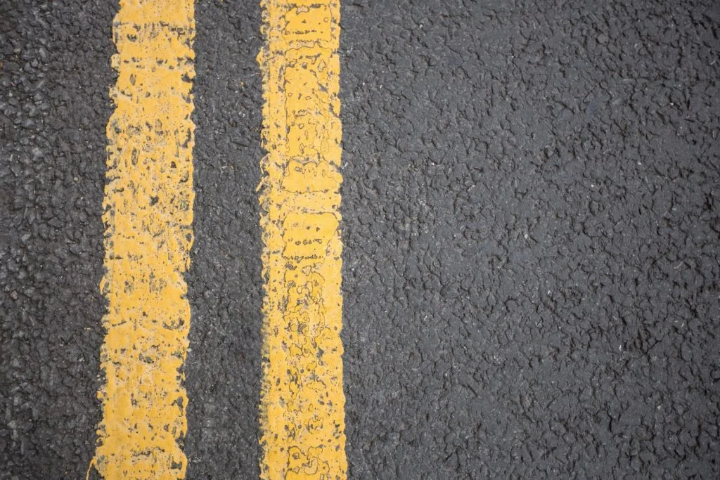A close up to double yellow lines on asphalt.