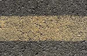 A close-up of a faded yellow road line.
