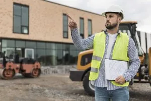 A construction work points at something off camera.