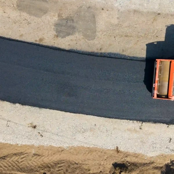 An aerial view of a new road paving paved and leveled.