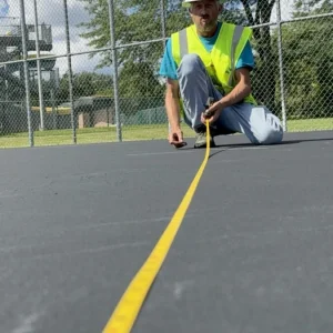 An NPP worker measurements with a measuring tape.