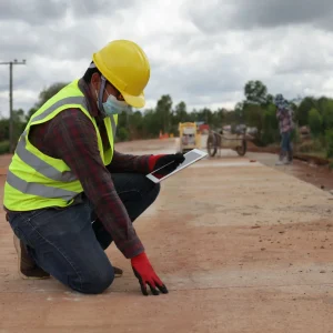 A contractor assess the newly dried concrete road.