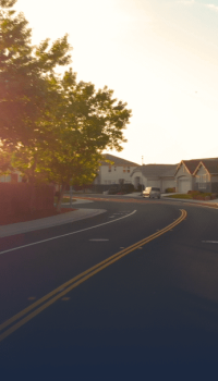 curvy road with houses in the background